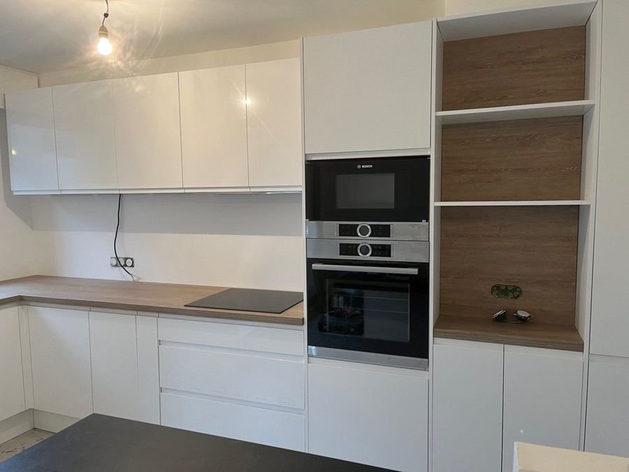 Cuisine blanche avec four et micro-ondes encastrés et niches en bois
