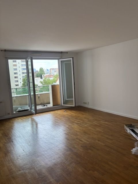 Parquet dans un séjour avec porte-fenêtre et balcon