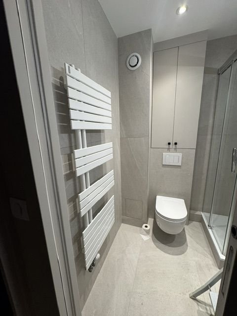 Salle d'eau avec WC suspendu et radiateur sèche-serviettes